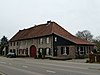 Hoeve van baksteen, gelegen aan een binnenplaats. Voorgevel gepleisterd. Neoclassicistische deur. Een geheel vormend met nr 92