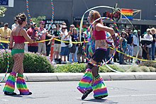 Two women performing with rainbow hula hoops