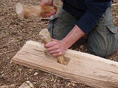 Arbeit mit rekonstruiertem jungsteinzeitlichen Knochenbeitel an einer Eichenbohle