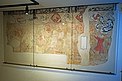 Die hinter Glas geschützte Wandmalerei zeigt eine mittelalterliche Festszene, in der getanzt wird. Ganz rechts ist ein Flötenspieler dargestellt. Über der Szene verläuft ein rund 40 Zentimeter hohes Band mit acht Wappenschildern und darüber ein dünneres Band, das mit Pflanzenranken bemalt ist.