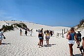 Beachgoers on the white sand dunes of Łeba