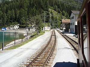 The station, with lake and station building to the left, and village houses to the right