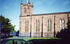 A stone church with lancet windows and a west tower with pinnacles