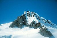 Mountain partly covered by glacial ice on a clear day.