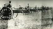Soldiers pose around a Maxim gun as if about to fire it