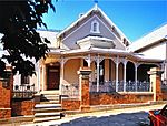 The front entrance of the house is closed by an e high teak Victorian door with coloured glass middle panels. The doorway gives into a short, high passage and this in turn brings the visitor into a hallway of considerable width, running the entire length Overpark is a fine Victorian verandah house in the Natal style. It was built in 1884 for a wealthy merchant in Pietermaritzburg and reflects his wealth in its size and quality of its architectural detailing as well as in the opulence of its interiors. Architectural style: Gothic Revival Style. Type of site: commercial Previous use: house. Current use: office. Turn into Loop Street (one-way) from Chapel Street. Building is on left just of end of redbrick wall. Overpark House, with its beautiful cast-iron trimmings and cast-iron fireplaces, dates from 1884 and is an excellent example of a Victorian veranda house in the Natal style.