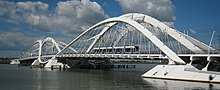 A tram crossing a curved double span bridge.