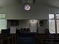 The Temple sanctuary. Visible on the bimah is the namesake ner tamid hanging before the Torah ark. To the right is the ornamental piece ("mizrach") depicting Jerusalem which marks the Mizrah