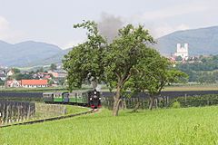 Auf der Feistritztalbahn kann man auch einen Sonderzug mit Dampflok mieten, rechts im Hintergrund die Weizbergkirche