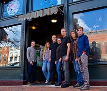 seven band members standing in front of a building