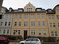 Mietshaus in geschlossener Bebauung mit Vorgarten und Einfriedung