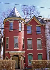 Narrow, red three-story house with turret
