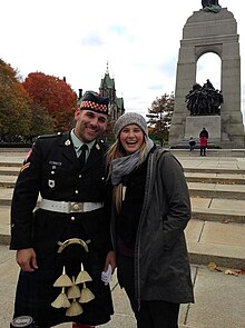 Photo of Corporal Nathan Cirillo being photographed in uniform next to a tourist days before his death at the tomb of the unknown soldier, seen in the background of the photo.