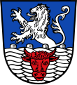 Gemeinde Stubenberg In Blau aus einem silbernen Flechtwerkszaun, der mit einem roten Ochsenkopf belegt ist, wachsend ein silberner Löwe.
