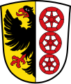 Gemeinde Kammerstein Gespalten; vorne in Gold ein rot bewehrter schwarzer halber Adler am Spalt, hinten in Silber übereinander drei sechsspeichige rote Räder.