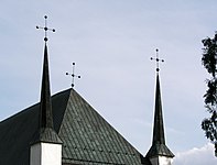 De Björklinge kyrka met twee geknikt ingesnoerde naaldspitsen.