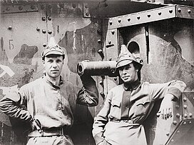 Two Red Army men, the commander of the Western Front motor transport depot (left) and a tank commander (right), in front of a British Mark V tank in Soviet service (Smolensk, summer 1920).