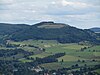 Blick vom Wachtküppel in Richtung Südosten zum Simmelsberg; vorne Häuser von Gersfeld, mittig rechts der waldlose Rodenbacher Küppel mit Häusern von Rodenbach, mittig links der Dammelhof