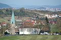 St. Hubertus von Osten mit Kirchplatz und Denkmal St. Sebastian vor dem Kirchturm