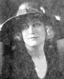 A young blond woman wearing a hat with a wide brim