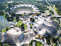 Olympiapark mit Ensemble aus Olympiahalle (rechts), Olympiastadion (hinten) und Olympia-Schwimmhalle (links unten)