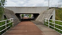 Onderdoorgang in talud Schipholdraaibrug; uiterst rechts een slagboom van de draaibrug; juni 2019.