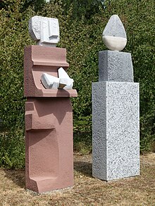 Lorenz Balmer-Gerber (1916–2004), Helene Balmer-Gerber (1924), Gemeinschaftswerk. Skulptur, Frau mit Weihgabe und Wächter, 1993. Granit, Marmor, Kalk- und Sandstein für das anonyme Gemeinschaftsgrab, Friedhof am Hörnli, Basel.