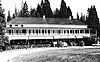 Historic photograph of the Wawona Hotel, a broad, two-story building with trees in the background.