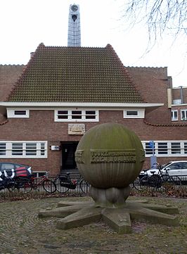 Het monument met op de achtergrond een gevelsteen van Trapman (maart 2013)