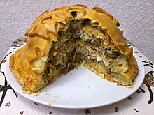 Kurnik filled with slices of chicken, mushrooms, blini, rice, eggs