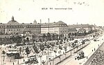 Gleisschleife Augustenburger Platz: Das im Vordergrund liegende Gleis führt am rechten Bildrand um den Platz, im Hintergrund vor dem Eingang zum Rudolf-Virchow-Krankenhaus wartet ein Zug der Städtischen Straßenbahn, 1914.