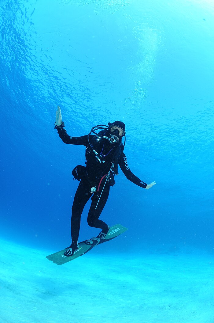 A woman breathing underwater with a scuba suit. Show another