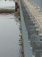 Das Triebwasser aus der Weser strömt nach rechts durch den Grobrechen zum Reinigungsbecken.