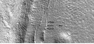 Close-up that shows cracks containing pits on the floor of a crater, as seen by HiRISE under HiWish program. Cracks may start as a line of pits that enlarge, then join.