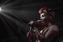 Shola Adisa-Farrar holding a microphone