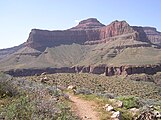 View of Tower of Set peak and sub-unit cliff section from Tonto Trail, Granite Gorge, north of Mohave Point, Grand Canyon Village, South Rim. The peak is behind and separated from a cliff unit (with small prominence), in front-(photo center, right, Tower of Set (peak) to its left). Vertical erosion in cliff of Redwall Limestone, upon horizontal Muav Limestone cliff.[19] The Tapeats Sandstone sits in foreground on Granite Gorge, and is seen as thinly-bedded. The slope-former above is the (dull-greenish)-Bright Angel Shale with thin, inter-bedding, as well as one resistant cliff unit. The Redwall Limestone cliff section in Grand Canyon is about 450 feet (137 m) thick.[20]