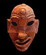 A Punic mask of a face featuring the symbol of Baal Hammon