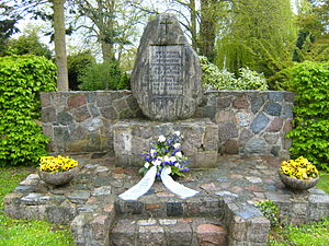 Blumen durch die Kirchengemeinde Niendorf (Ostsee) zum 70. Jahr der Cap-Arcona-Tragödie am Gedenkstein auf dem Friedhof von Niendorf (Ostsee) für 113 Opfer