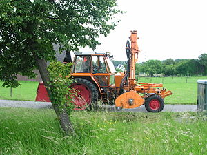 Fendt-Geräteträger mit aufgebautem Mäher und oranger Kommunallackierung