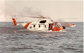 Wasserung einer Sikorsky HH-3F Pelican der US-Küstenwache auf dem Meer bei einem brennenden Boot