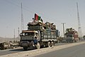 Kamyonlarında üç renkli Afgan bayrağıyla Pakistan'dan dönen Afgan mülteciler (2004)