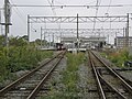 A view of the platforms and tracks. The train is standing on track 3 which is a siding. To the right, some sidings can be seen between the island platform and the station building.