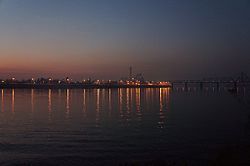 Evening view of Rybalskyi Peninsula from Trukhaniv Island with the Rybalskyi Railroad Bridge [uk] on the right.