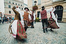 Na zdjęciu trzy tańczące pary w strojach ludowych. Znajdują się na rynku w Lublinie. Wokół zgromadzeni widzowie klaszczą.