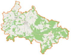 Mapa konturowa powiatu białogardzkiego, w centrum znajduje się owalna plamka nieco zaostrzona i wystająca na lewo w swoim dolnym rogu z opisem „Jezioro Dobrowieckie Małe”