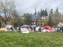 The pro-Palestine "Popular University for Gaza" encampment at the University of Oregon on the Memorial Quad in front of the Lillis Business Complex in April 2024. A sign in front reads "Divest from Death."