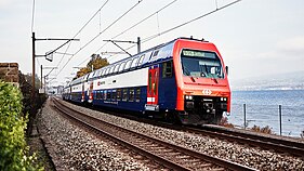 Eine doppelstöckige Zürcher S-Bahn fährt auf einem Gleis in Seenähe