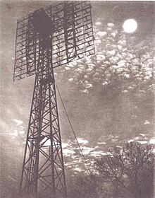 A SCR-271 radar tower facing the moon at night.