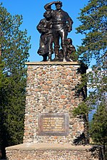 Fotografi av minnesmerke i Donner Memorial State Park, bronsestatue på steinpidestall.