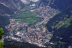 Die Stadt Landeck in Tirol mit der Trasse der Arlbergbahn (im Vordergrund) und dem Bahnhof Landeck-Zams sowie der Inntal Autobahn A 12.